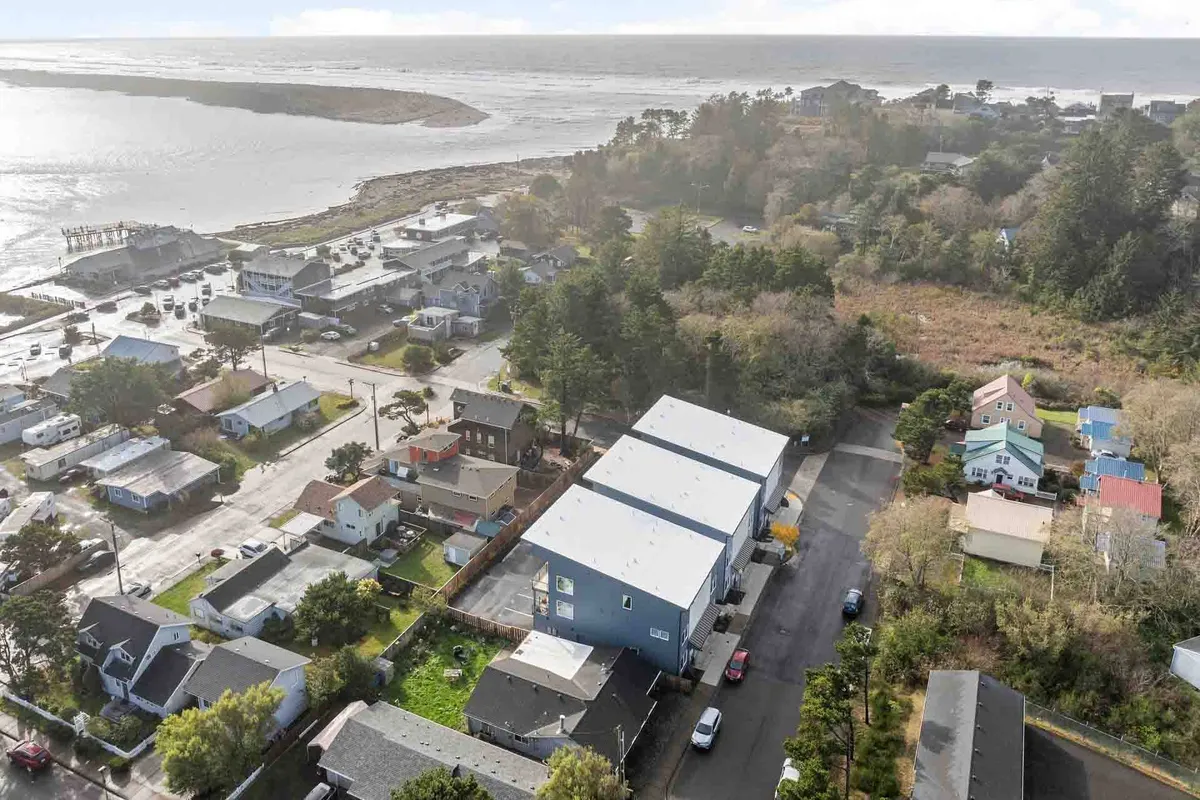 A panoramic view of a coastal residential area, with gently winding roadways, green lawns, and the ocean stretching into the distance. The neighborhood exudes peace and invites outdoor activity, from neighborhood strolls to seaside adventures.